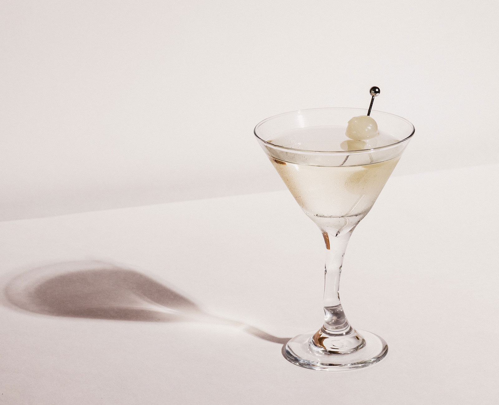 Reverse Whisper Martini with cocktail onions on a white background with a shadow