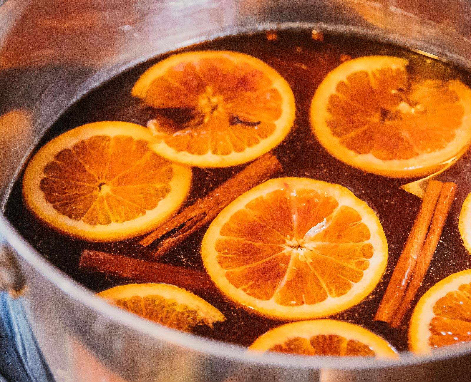 Pot of Mulled Vya with orange slices and cinnamon sticks